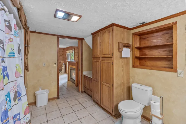 a bathroom with a toilet and a shower curtain