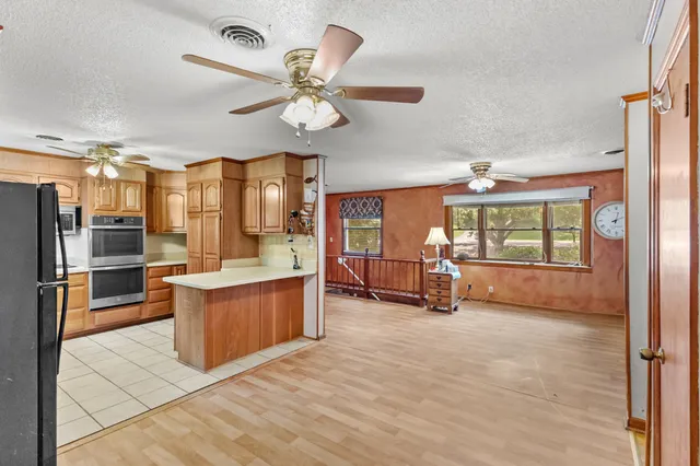 a living room with stainless steel appliances kitchen island granite countertop furniture and a kitchen view