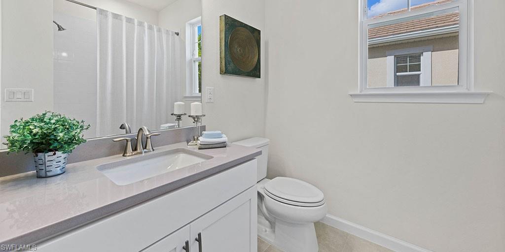 4653 Arboretum Circle, Unit 104 Naples, FL 34112 - Photo 17 of 21 a bathroom with a sink a toilet and mirror