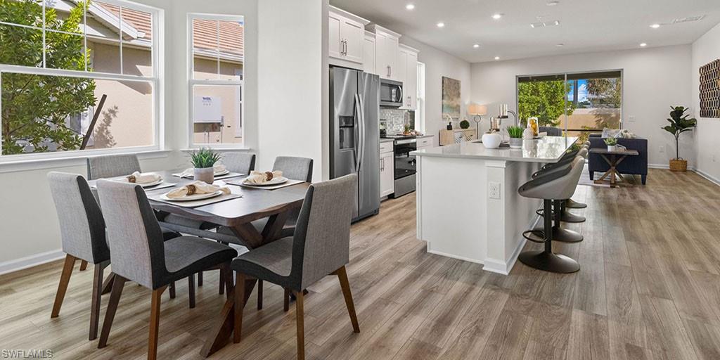 4653 Arboretum Circle, Unit 104 Naples, FL 34112 - Photo 7 of 21 a view of a dining room with furniture window and wooden floor