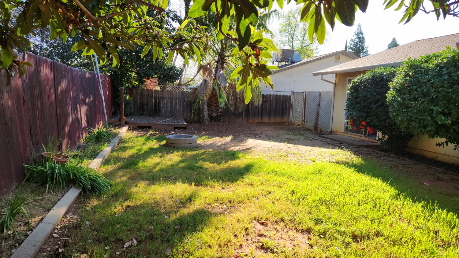 2332 Venus Way Redding, CA 96002 - Photo 26 of 27 a view of backyard with wooden fence and large trees