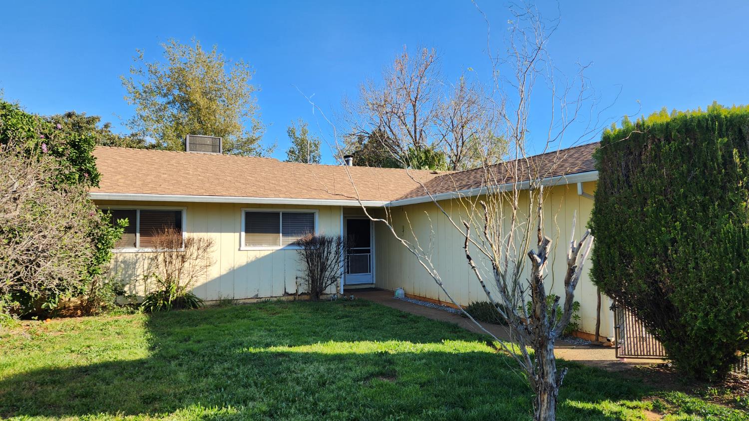 2332 Venus Way Redding, CA 96002 - Photo 6 of 27 a view of a white house with a yard plants and large tree