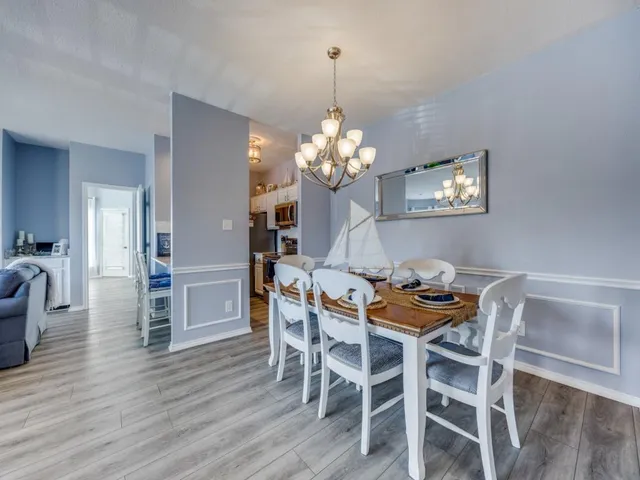a dining room with furniture a chandelier and wooden floor
