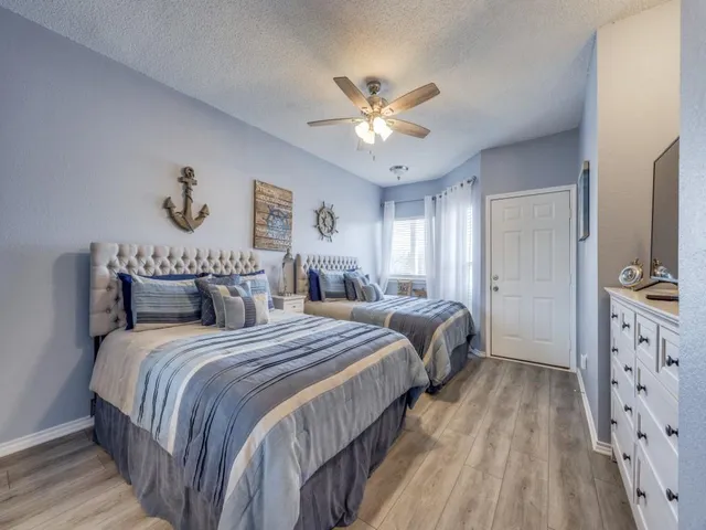 a bedroom with a bed and a flat tv screen on dresser