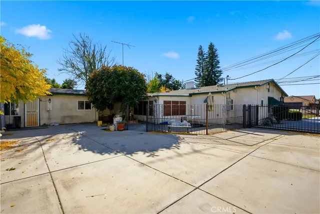 a white house with a large trees next to a yard