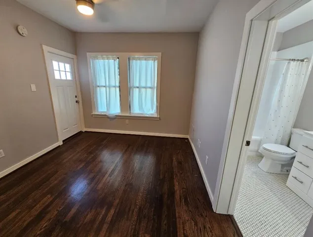 a spacious bathroom with a double vanity sink a toilet a mirror and a bathtub