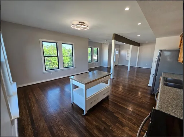 a kitchen with stainless steel appliances a stove a sink a refrigerator a window and cabinets