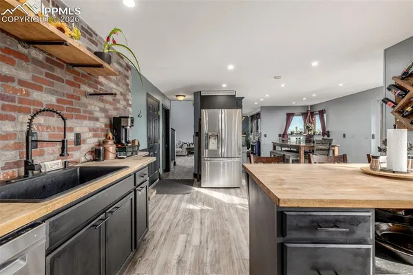 a kitchen with stainless steel appliances granite countertop a sink a stove and cabinets