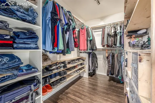 a view of walk in closet with clothes and shoes