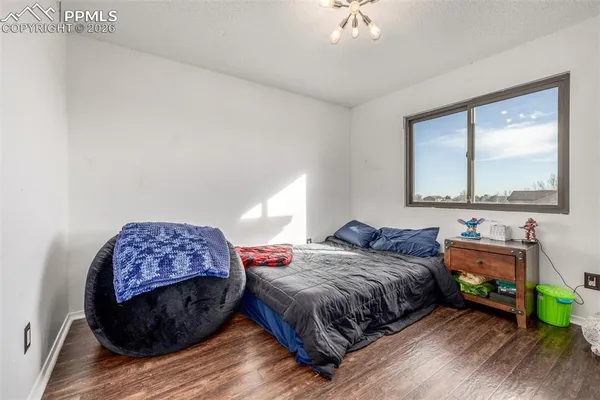 a bedroom with a bed and a dresser next to a window