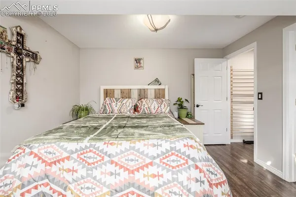 a large bed sitting in a bedroom next to a window and a wooden floor