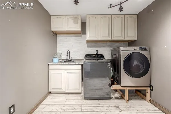 a utility room with sink dryer and washer