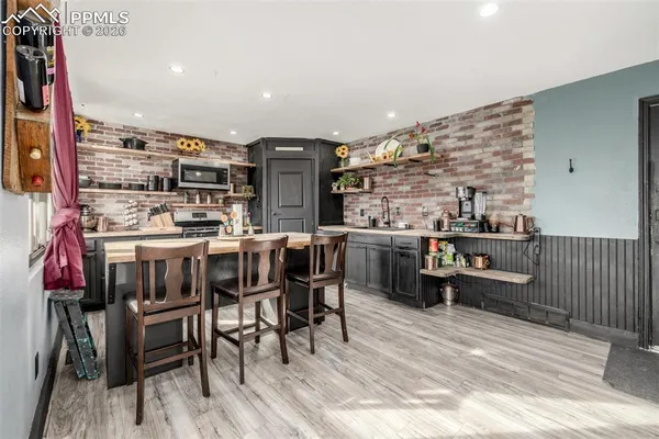 a open kitchen with stainless steel appliances a stove a sink dishwasher and cabinets with wooden floor
