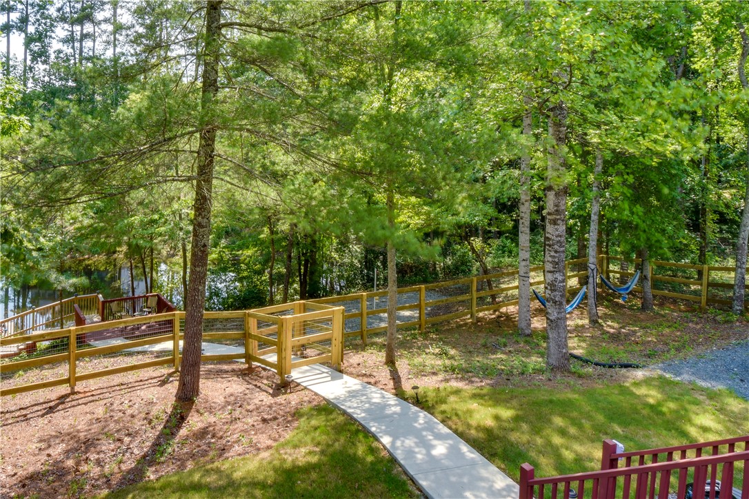 206 Petty Road Seneca, SC 29672 - Photo 39 of 48 A tranquil pathway descends through lush trees, leading to a private waterfront deck and serene hammocks.