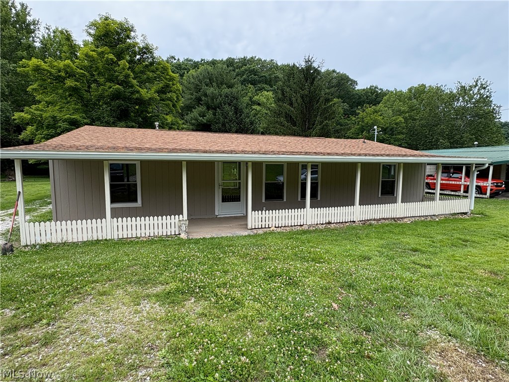 1448 Winding Road Parkersburg, WV 26104 - Photo 1 of 12 Single-story residence featuring a covered front porch with white picket fencing, a brown shingle roof, and light brown siding