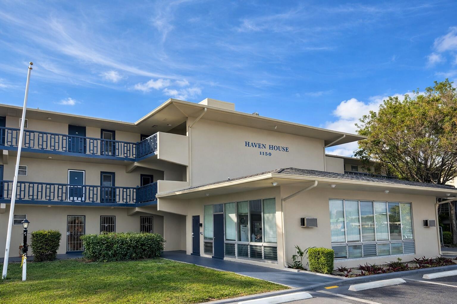 1150 East Sample Road, Unit 312 Pompano Beach, FL 33064 - Photo 11 of 11 a view of a white building among the street with palm trees