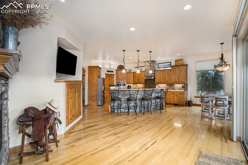 11628 Shaugnessy Road Colorado Springs, CO 80908 - Photo 11 of 50 a living room with furniture a flat screen tv and kitchen view