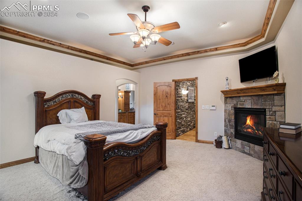 11628 Shaugnessy Road Colorado Springs, CO 80908 - Photo 18 of 50 a bedroom with a bed and a fireplace