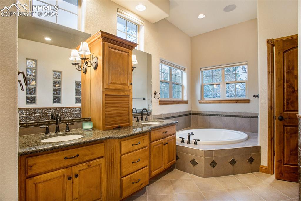 11628 Shaugnessy Road Colorado Springs, CO 80908 - Photo 20 of 50 a bath room with a sink double vanity tub and a mirror