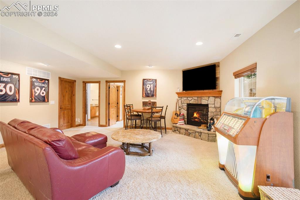 11628 Shaugnessy Road Colorado Springs, CO 80908 - Photo 24 of 50 a living room with furniture a fireplace and a flat screen tv