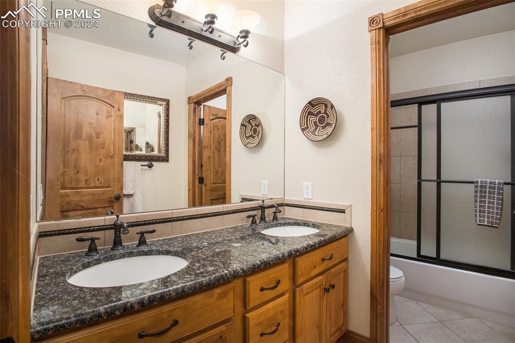 11628 Shaugnessy Road Colorado Springs, CO 80908 - Photo 27 of 50 a bathroom with a granite countertop sink and a mirror