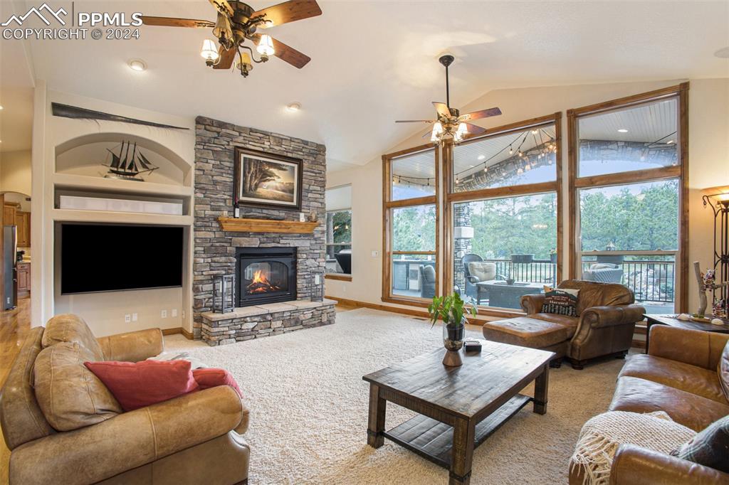 11628 Shaugnessy Road Colorado Springs, CO 80908 - Photo 5 of 50 a living room with furniture a large window and a fireplace