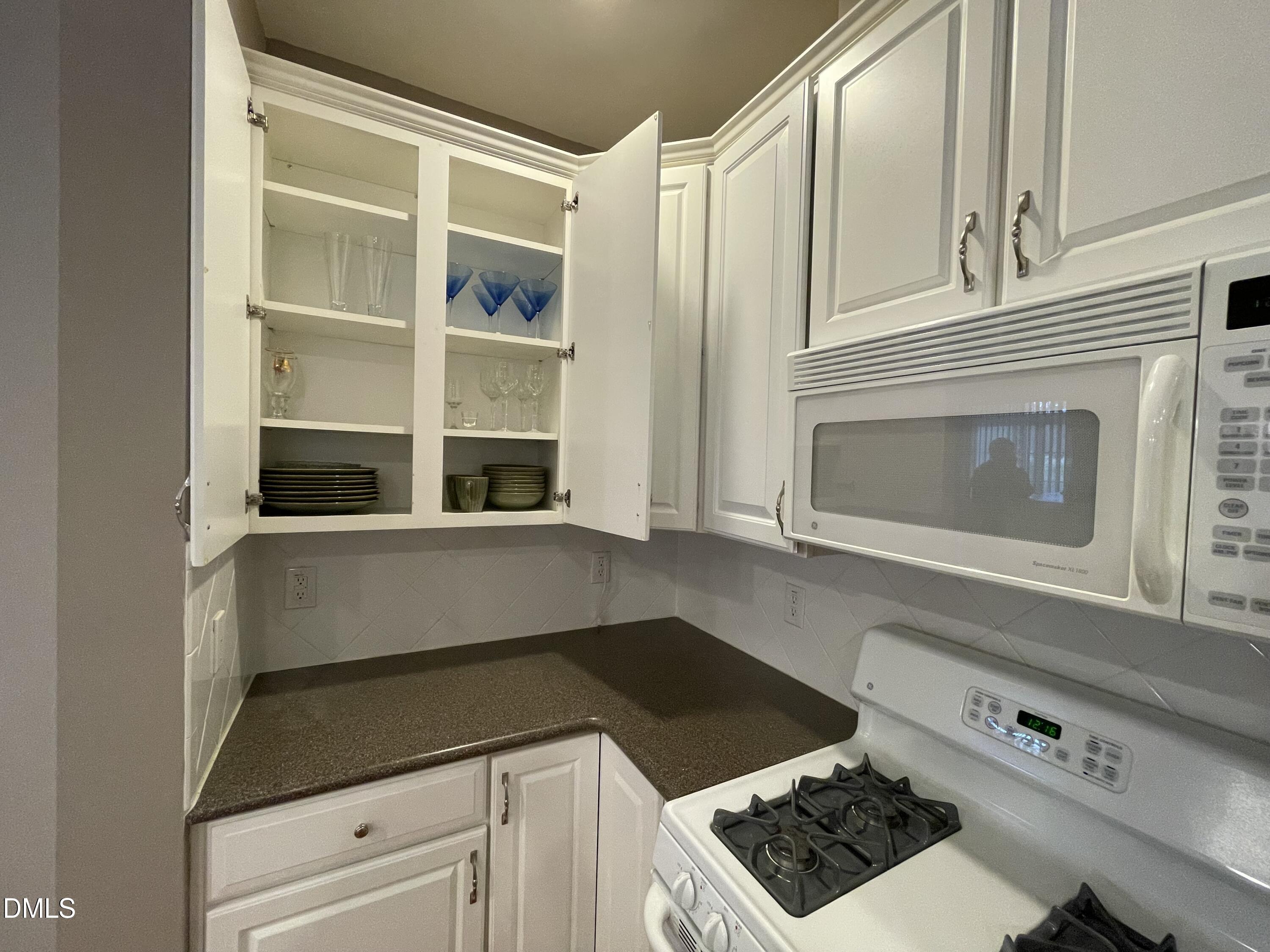 10411 Rosegate Court, Unit 3 Raleigh, NC 27617 - Photo 14 of 62 a kitchen with a stove and white cabinets