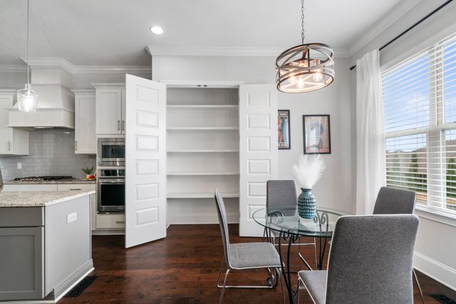 a view of a dining room with furniture a chandelier and wooden floor