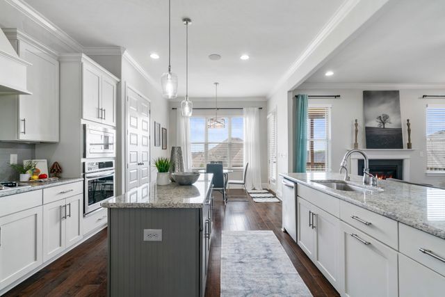 a large kitchen with kitchen island white cabinets and stainless steel appliances