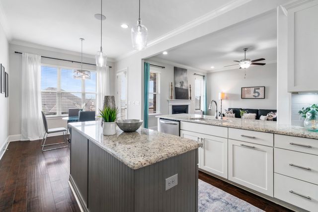 a kitchen with granite countertop kitchen island white cabinets and refrigerator