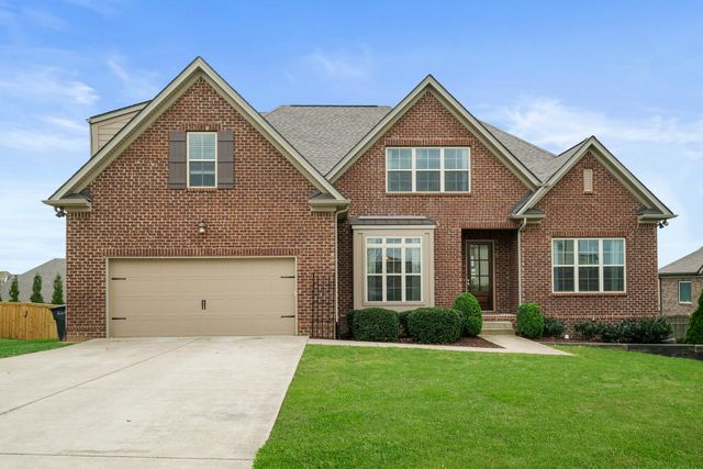 a front view of a house with a yard and garage
