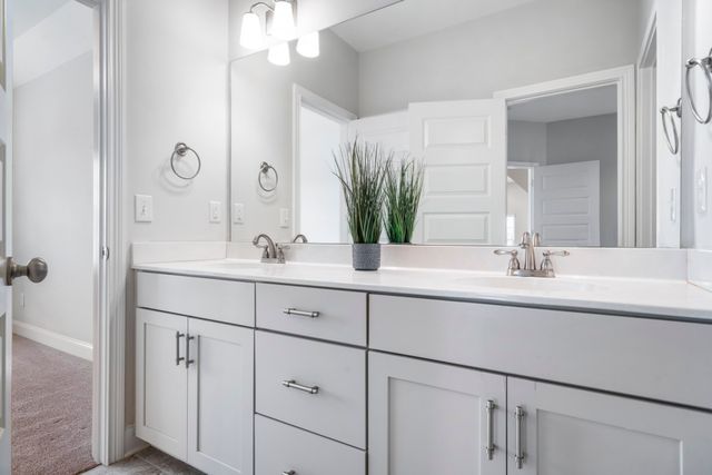 a bathroom with double vanity sinks and a mirror