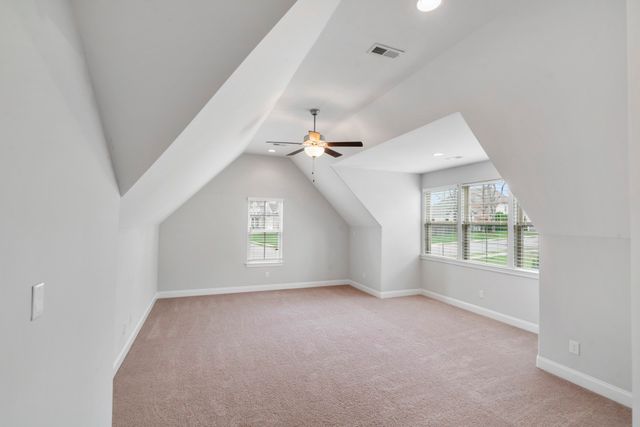 an empty room with windows and ceiling fan