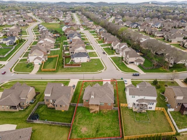 an aerial view of a pool yard and mountain view in back