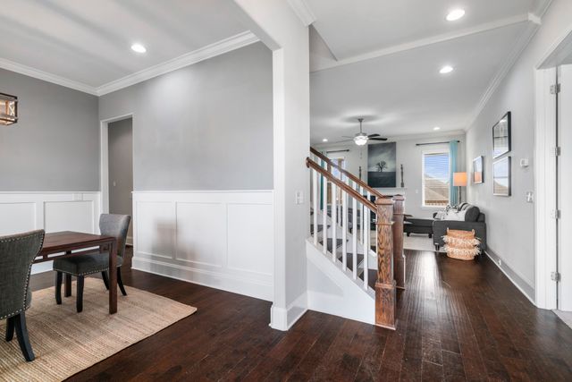 a view of a hallway with wooden floor and dining room