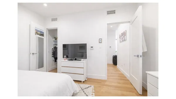 a bedroom with a bed and a flat screen tv