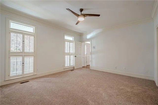 a view of an empty room with wooden floor and stairs