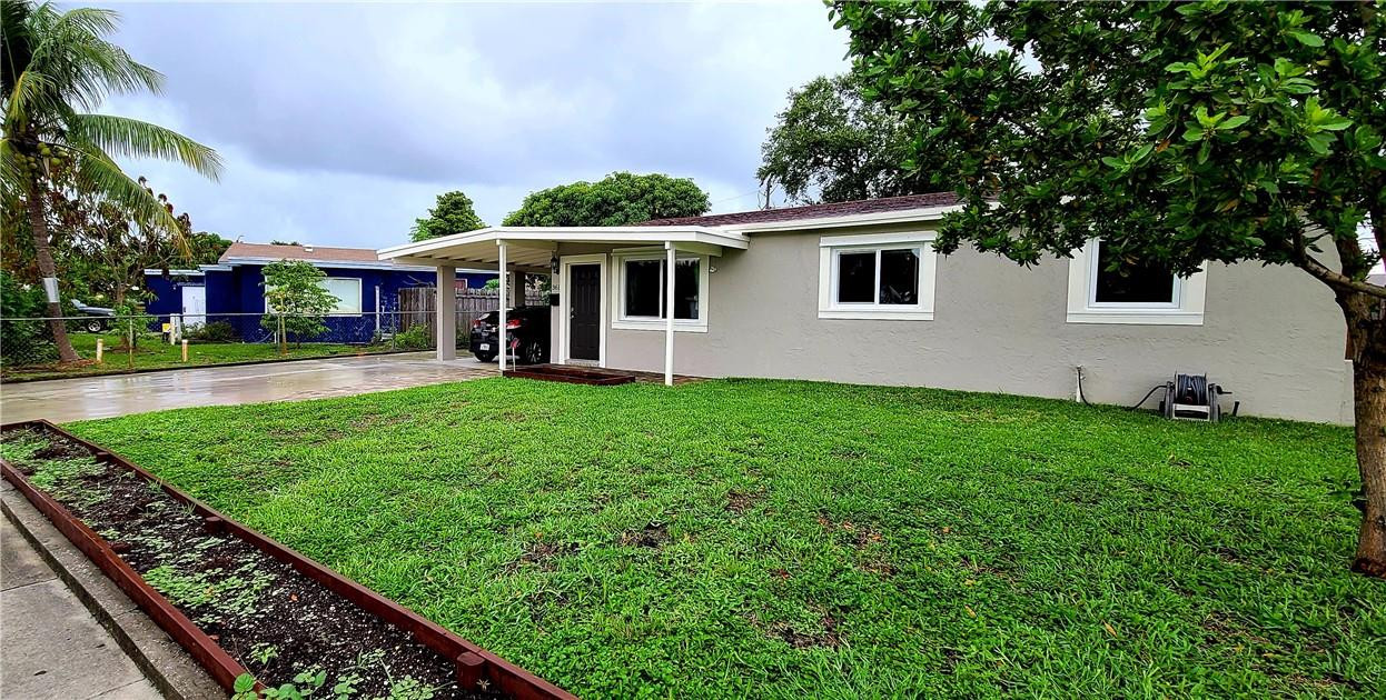 361 Northwest 37th Street Pompano Beach, FL 33064 - Photo 2 of 21 a front view of a house with a yard and trees