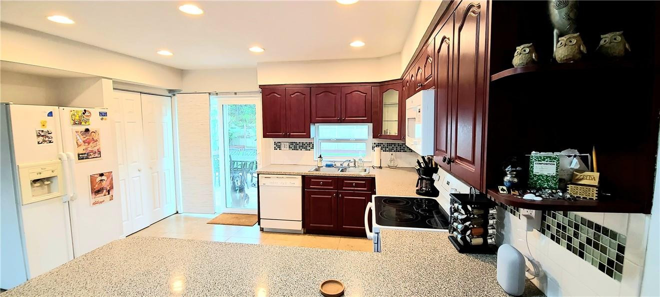 361 Northwest 37th Street Pompano Beach, FL 33064 - Photo 7 of 21 a kitchen with stainless steel appliances kitchen island granite countertop a refrigerator and a stove top oven