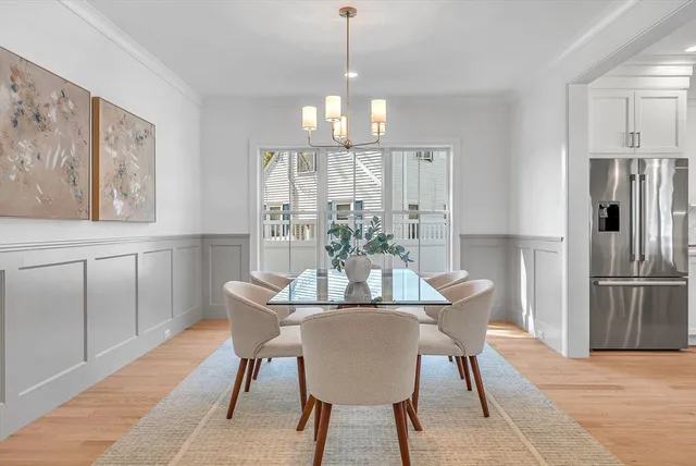 a dining room with furniture a chandelier and wooden floor