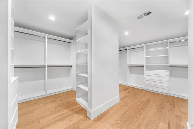 a view of an empty room with wooden floor and closet