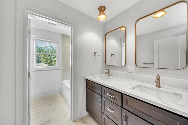 a bathroom with a granite countertop double vanity sink and a mirror
