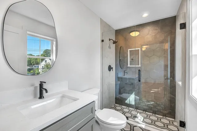 a bathroom with a sink a toilet and shower