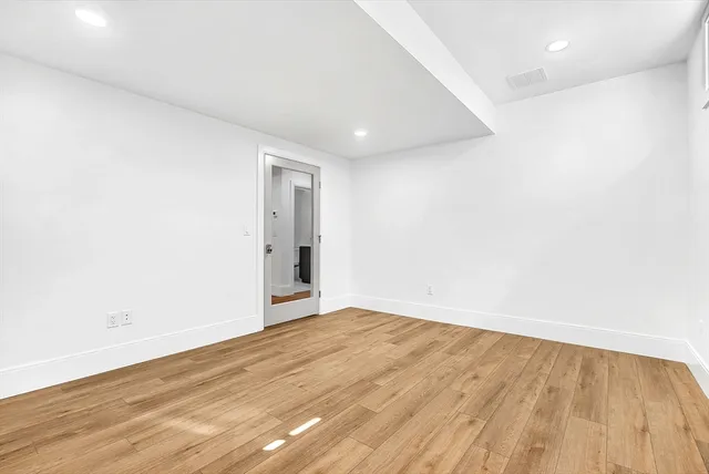 a view of an empty room with wooden floor