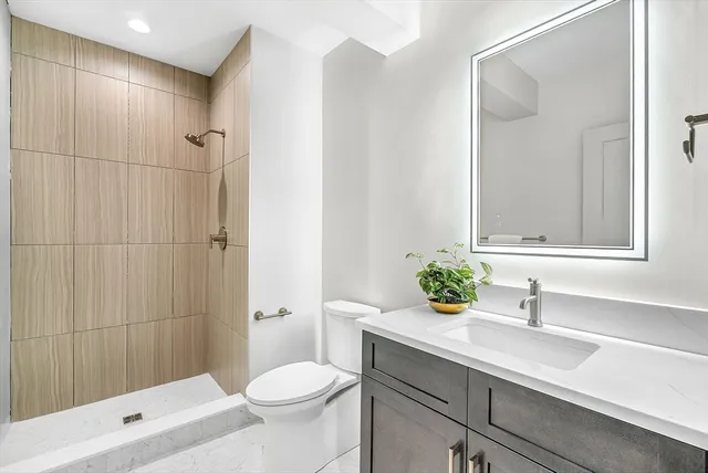 a bathroom with a sink a toilet and shower