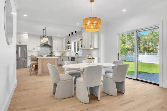 a view of a dining room with furniture a chandelier and wooden floor