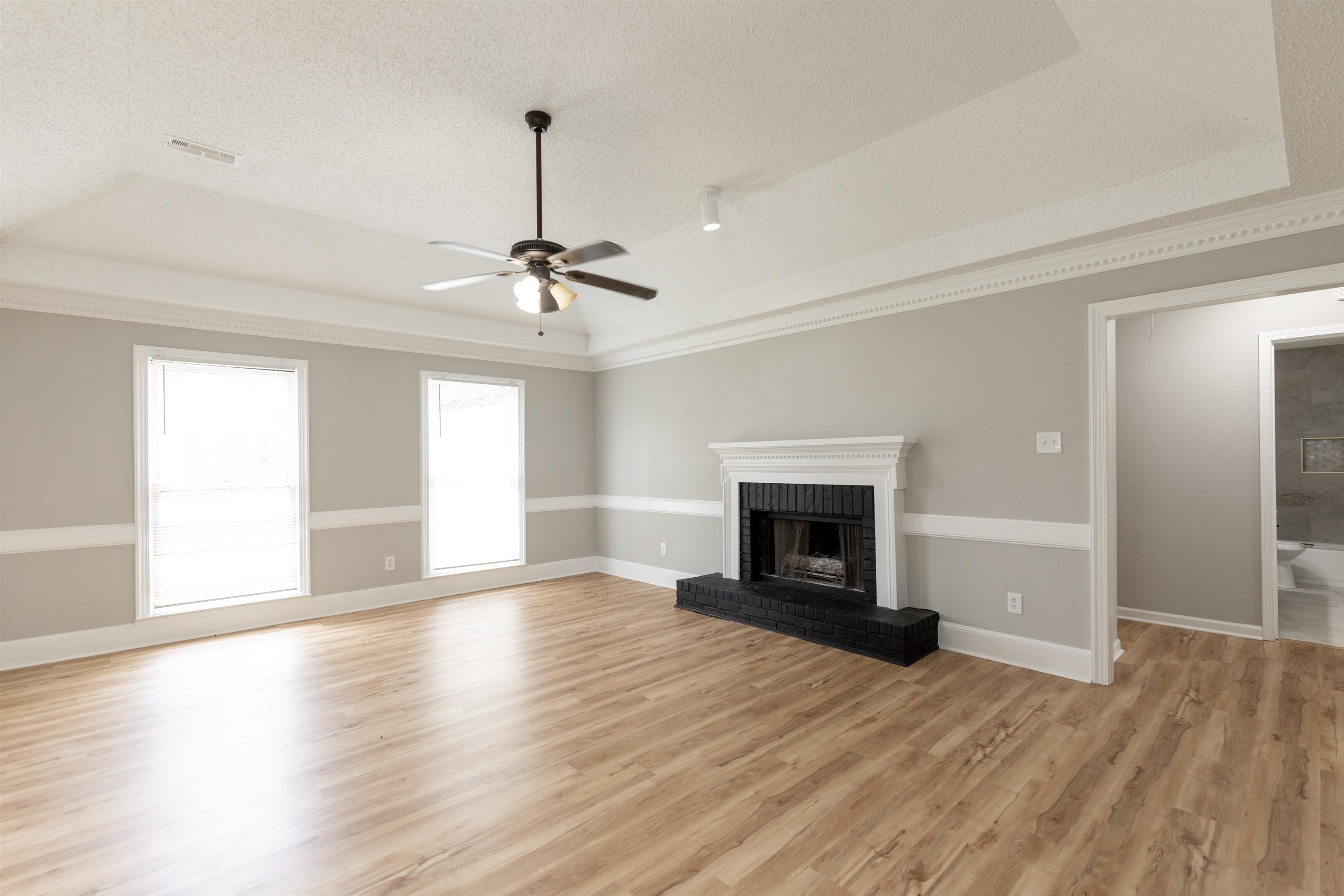 7421 Richmond Road Memphis, TN 38125 - Photo 7 of 39 Spacious living area featuring wood-finish flooring, a tray ceiling, and crown molding
