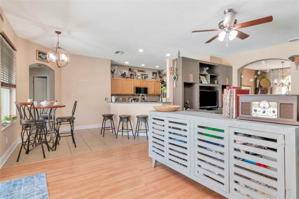 19103 Wind Dancer Street Lutz, FL 33558 - Photo 9 of 41 a kitchen with stainless steel appliances kitchen island granite countertop a stove a refrigerator a dining table and chairs with wooden floor