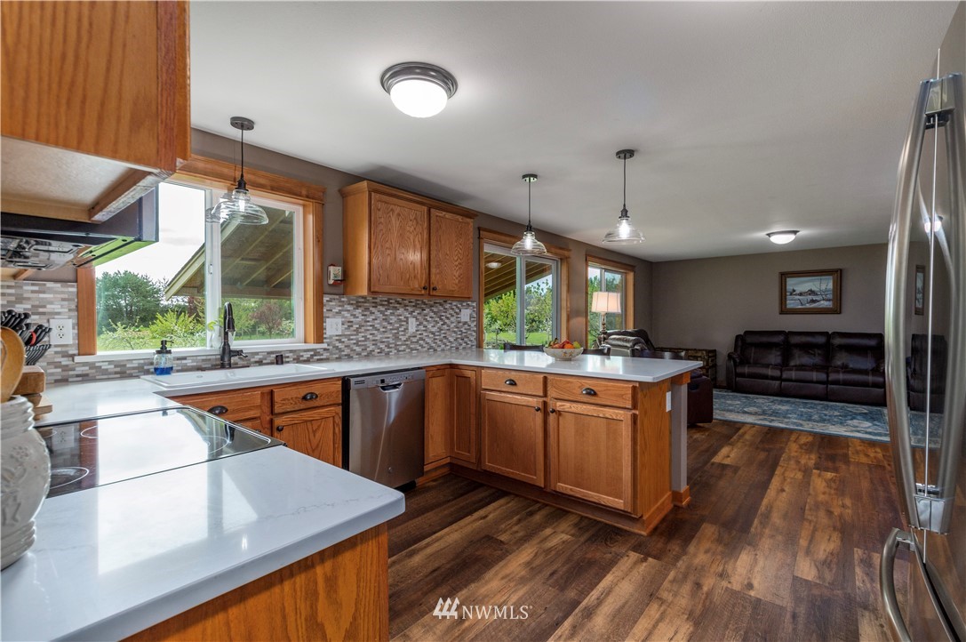 6519 190th Trail Southwest Rochester, WA 98579 - Photo 14 of 40 a kitchen with stainless steel appliances granite countertop a sink a stove and a wooden floors