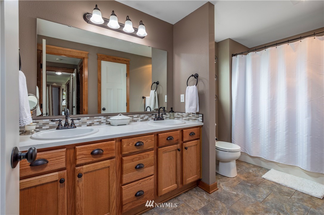 6519 190th Trail Southwest Rochester, WA 98579 - Photo 22 of 40 a bathroom with a granite countertop sink a toilet and a mirror